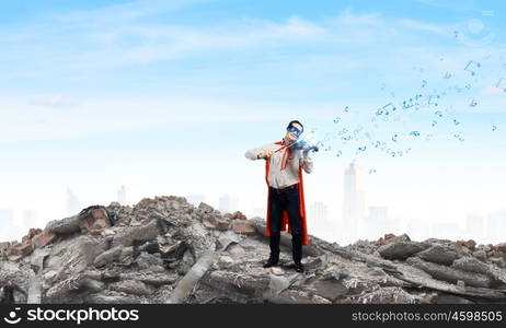 Superman with violin. Young man in superhero costume playing violin