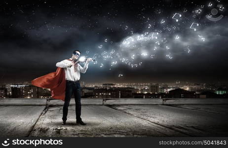 Superman with violin. Young man in superhero costume playing violin