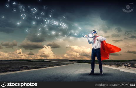 Superman with violin. Young man in superhero costume playing violin