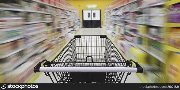 Supermarket aisle with empty shopping cart, Supermarket store abstract blurred background with shopping cart.