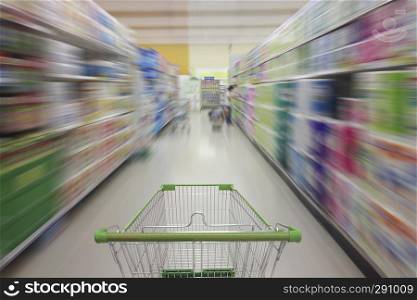 Supermarket aisle with empty shopping cart, Supermarket store abstract blurred background with shopping cart.