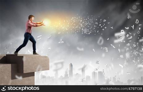 Supernormal man. Young man in casual throwing light splashes