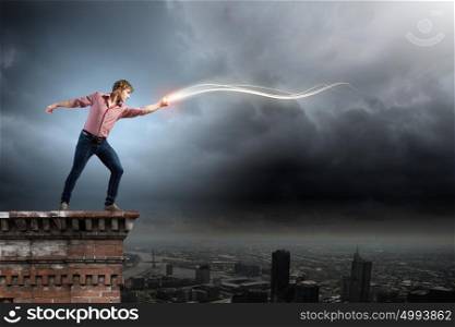Supernormal man. Young man in casual throwing light splashes