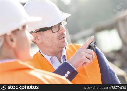 Supervisor showing something to colleague at construction site