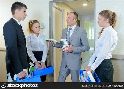 Supervisor with hotel personnel looking at cleaning products