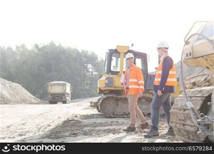 Supervisors walking at construction site against clear sky