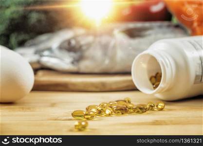 Supplement Bottle with Gel Capsules On a Wooden Table. Natural Food Sources of Vitamin D In Background. . Vitamin D Gel Capsules and Natural Sources of Vitamin D