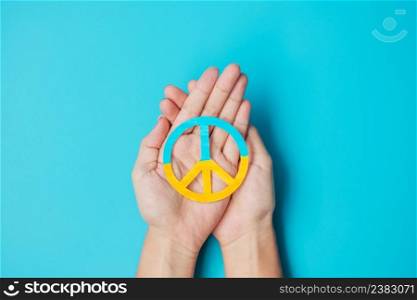 Support for Ukraine in the war with Russia, Hands holding symbol of peace with flag of Ukraine. Pray, No war, stop war, stand with Ukraine and Nuclear Disarmament