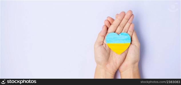 Support for Ukraine in the war with Russia, Hands holding symbol of Heart with flag of Ukraine. Pray, No war, stop war and  stand with Ukraine 