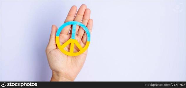 Support for Ukraine in the war with Russia, Hands holding symbol of peace with flag of Ukraine. Pray, No war, stop war, stand with Ukraine and Nuclear Disarmament