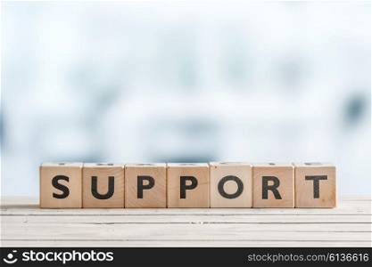 Support sign with blocks on a wooden office desk