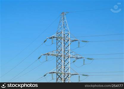 Supports high-voltage power lines against the blue sky.. Supports high-voltage power lines against the blue sky