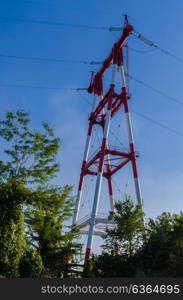 supports of high-voltage power lines against the blue sky