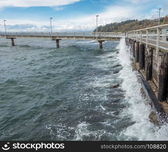 Surf crashes against a wood seawall resulting in whitewater explosions.