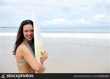 Surf girl holding a board in Brazil