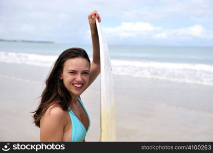 Surf girl holding a board in Brazil