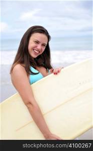 Surf girl holding a board in Brazil