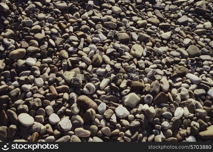 Surface covered with gray stones rounded pebbles closeup&#xA;