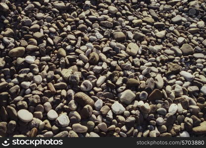 Surface covered with gray stones rounded pebbles closeup&#xA;