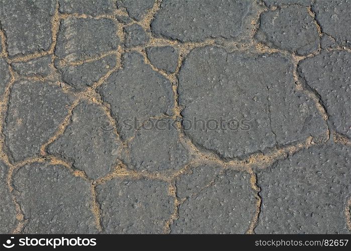 Surface of grey cracked asphalt background.