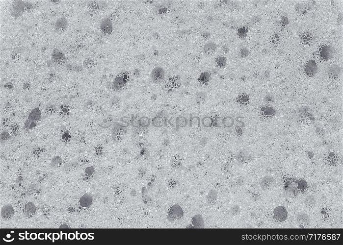 Surface of the porous foam sponge in white color.Background or texture. Close up.