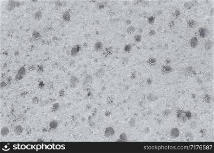 Surface of the porous foam sponge in white color.Background or texture. Close up.