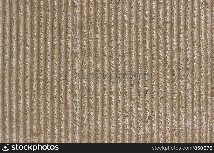 Surface of the wall with a decorative light beige plaster. Textured concrete wall with vertical lines and stripes as a texture or background. Seamless texture for background. Repair, design concept.
