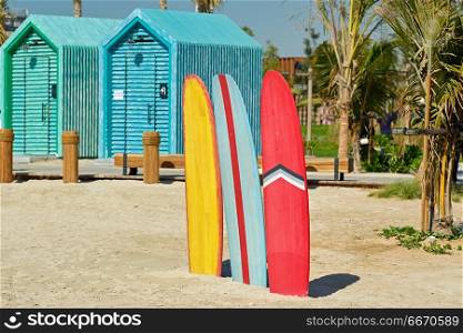Surfboards and bathing cabins in Dubai. Colored surfboards and beach bathing cabins in Dubai, United Arab Emirates