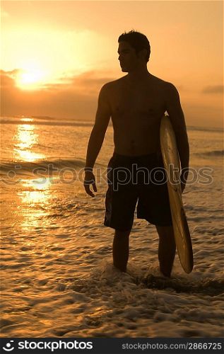 Surfer among Waves at Sunset