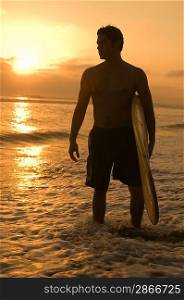 Surfer among Waves at Sunset
