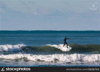 surfer black wetsuit riding the wave