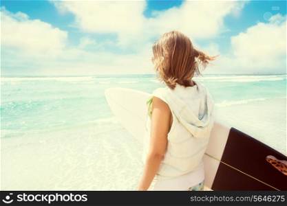 Surfer girl at the beach with her surfboard