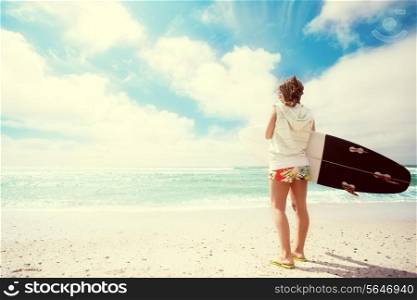 Surfer girl at the beach with her surfboard