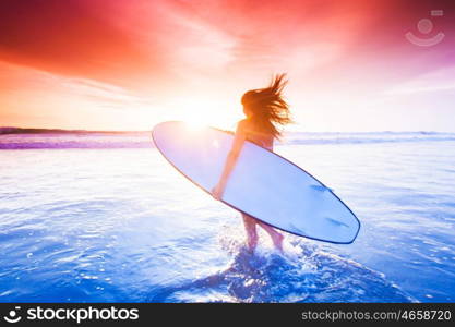 Surfer girl on beach at sunset. Beautiful sexy surfer girl on the beach at sunset