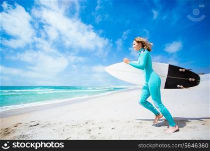 Surfer girl running at the beach with her surfboard