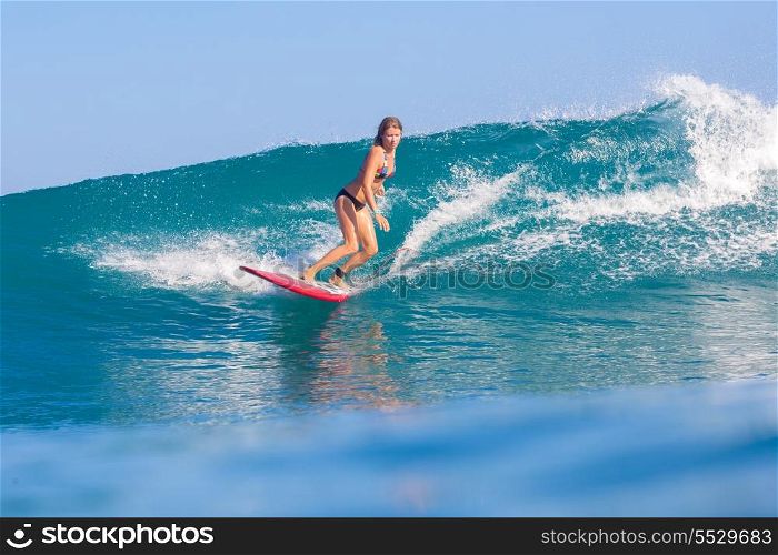 Surfer girl surfs a wave in Indian ocean.