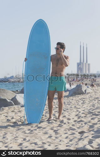 Surfer holding his blue surfboard