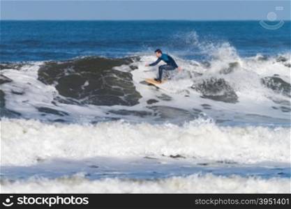 Surfer in action on the ocean waves on a sunny day.
