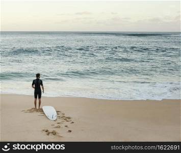 surfer man looking sea horizontal long shot
