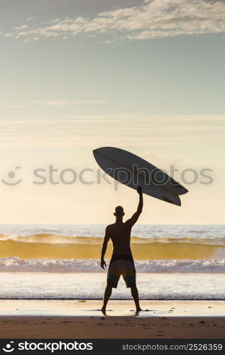 Surfer on the beach rising is surfboerd