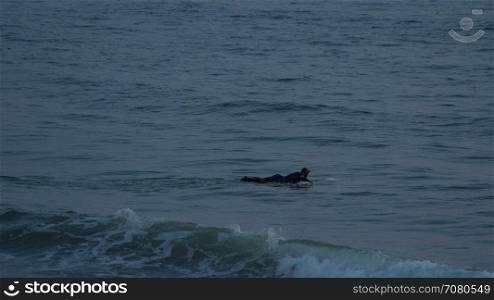 Surfer paddles out near Mesa Beach