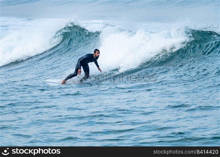 Surfer performing a bottom turn on a small wave.