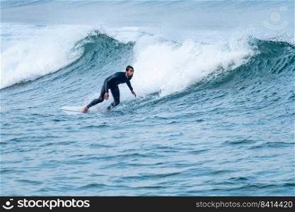 Surfer performing a bottom turn on a small wave.