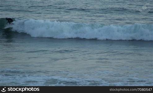Surfer rides wave near Mesa Beach