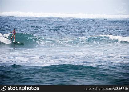 Surfer riding rocky waves