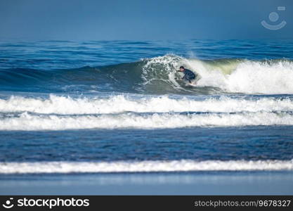 Surfer riding waves in Furadouro Beach, Portugal. Men catching waves in ocean. Surfing action water board sport. people water sport lessons and beach swimming activity on summer vacation.