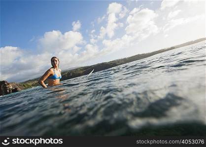 Surfer sitting on board in water