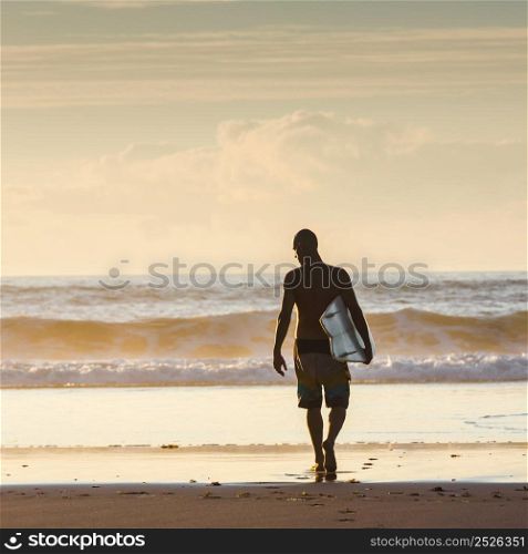 Surfer walking into the waves