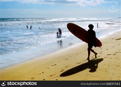 Surfer with surfer on the beach in the bright sunny day. Bali island, Indonesia