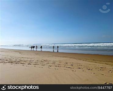 Surfers at bright sunny day on the beach. Arrifana, Alentejo, Portugal